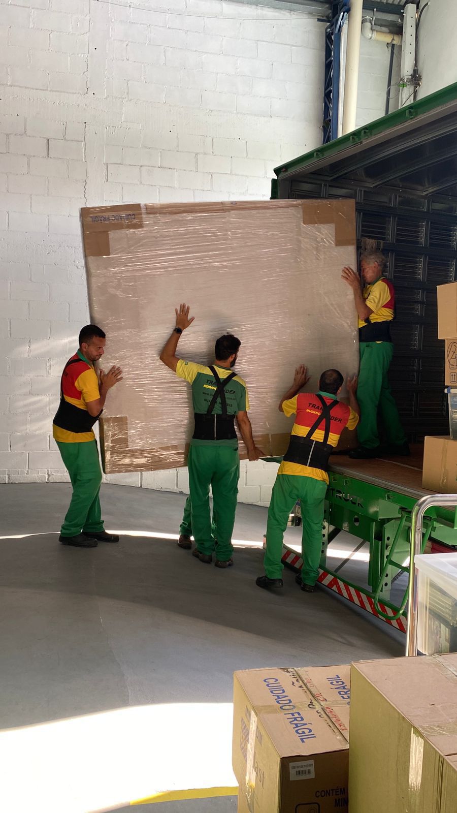 Equipe da Translíder carregando móvel embalado no caminhão de mudança
